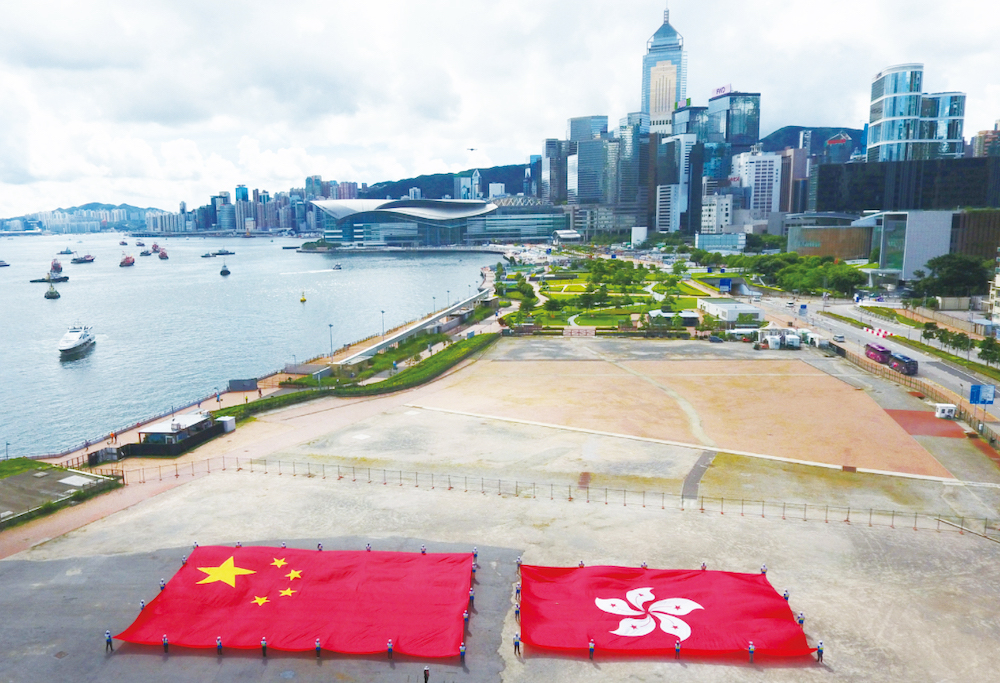 1         施政報告以兩個專章詳盡闡述中央對“一國兩制”方針堅定不移、對香港特區一貫支持。圖為在香港中環展示的國旗和區旗（圖：新華社）.jpg